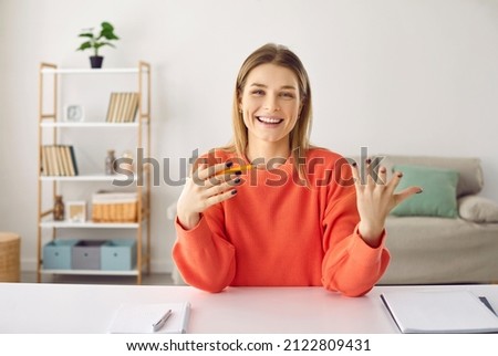 Positive woman talking and conducting online counseling or training while sitting in home office. Female online teacher, tutor or trainer having fun telling something while sitting in front of webcam.