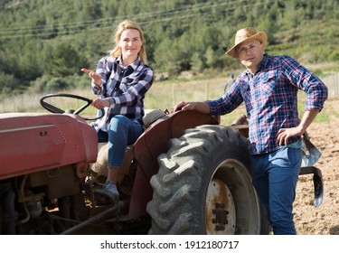 Positive Woman Working On Small Farm Tractor. High Quality Photo