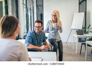 Positive Work Enviroment. Colleagues Talking While Working In Open Co-working Space.