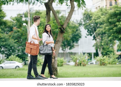 Positive Young Business People Walking In Park And Discussing Business And New Ideas