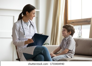 Positive young female doctor or nurse consult talk with little boy patient in private clinic or hospital, smiling woman pediatrician speak checkup visit small child at home, good medicine concept - Shutterstock ID 1733404940