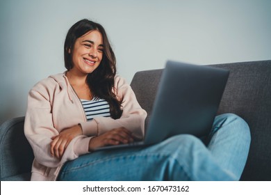 Positive Young Female Psychologist Having Online Call With Patient Via Laptop Computer Sitting On Couch At Home, Woman Having Video Chat With Friends Laughing And Smiling Happy, Communication Concept