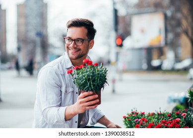 Positive Young Man Buying Flowers Outdoors.