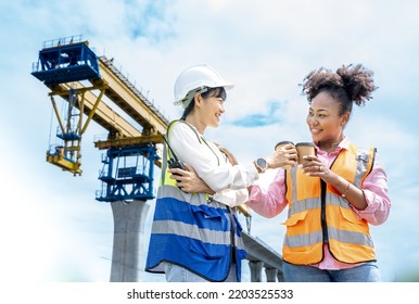 Positive Young Multi Ethnic Diversity Female Construction Workers Drinking Coffee From Disposable Cups And Talking While Resting During Break.Civil Engineer Bridge Project .Project Manager Smiling.