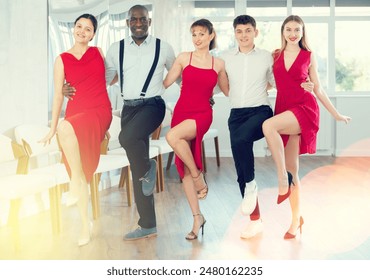 Positive young multinational people forming line while rehearsing traditional Irish stepdance in modern dance studio - Powered by Shutterstock