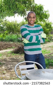 Positive Young Pakistani Man In Garden Before Harvesting Outdoor