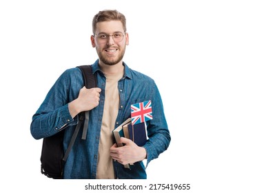Positive young student with books, backpack and UK flag standing over white studio background. Happy man studying at english university on exchange program. - Shutterstock ID 2175419655