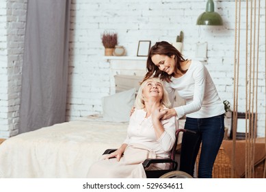 Positive young woman taking care of her grandmother in wheelchair - Powered by Shutterstock