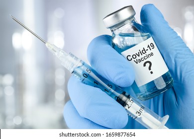 Possible Cure Concept With A Hand In Blue Medical Gloves Holding Coronavirus, Covid 19 Virus, Vaccine Vial