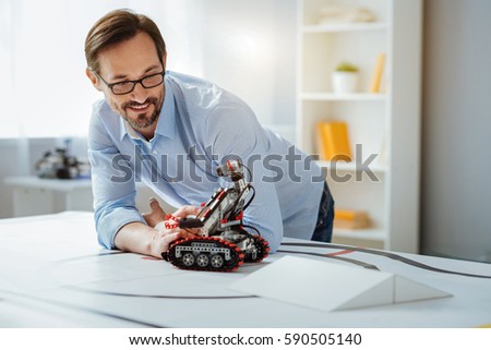 Possitive professional engineer testing robot in a lab