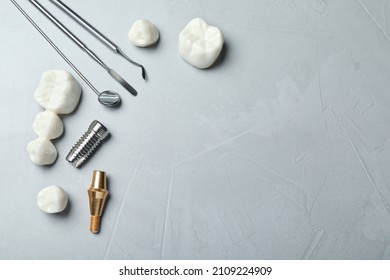 Post, abutment and different crowns of dental implant near medical tools on grey background, flat lay. Space for text - Shutterstock ID 2109224909