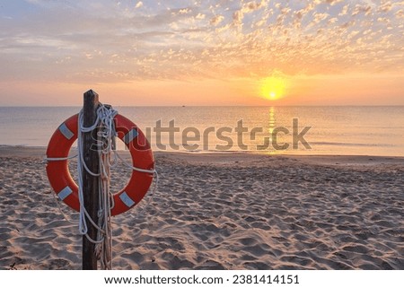 Post with lifeguard float on the beach shore