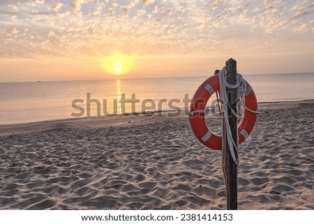 Post with lifeguard float on the beach shore