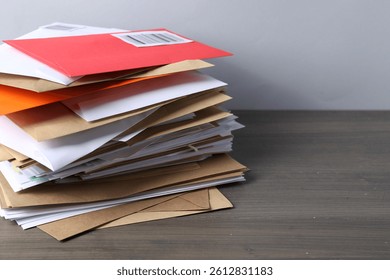 Post office. Stack of different paper envelopes on wooden table, closeup. Space for text