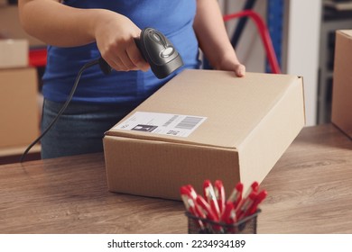 Post office worker with scanner reading parcel barcode at counter, closeup - Shutterstock ID 2234934189