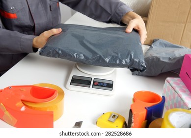 Post Office Worker Weighs The Parcel Before Sending