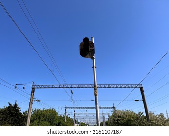 A post with stoplight at the railway station. A stop light mounted on a high pole at the platform against electric wires, powerline and cables - Shutterstock ID 2161107187