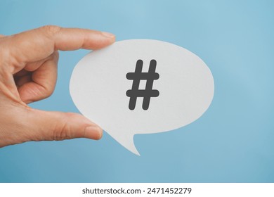 For post viral web network media tag marketing trending, blogging blog website strategy concept. hashtag ,hashtag sign on white real speech bubble in hand with blue background - Powered by Shutterstock