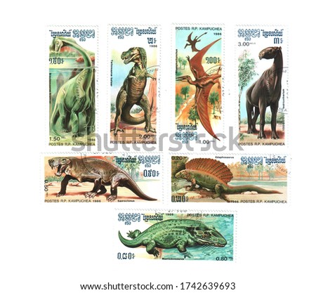 Postage stamps with the image of dinosaurs in 1976, laid out on a white background. Stamps can be redeemed in different categories and prices. The concept of philately hobby.