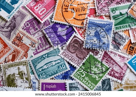 Postage stamps.A collection of world stamps in a pile.Postage stamps from different countries and times