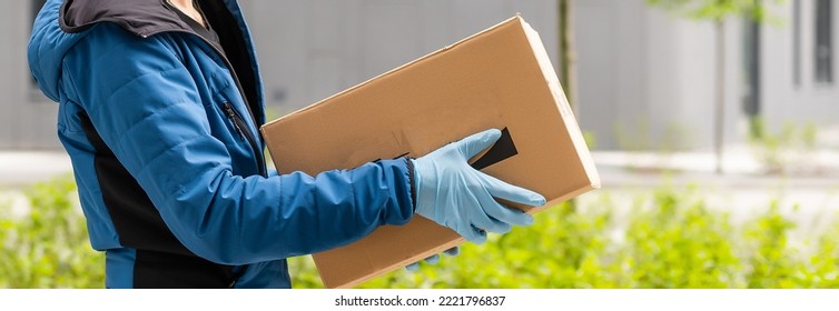 Postal Delivery Courier Man Wearing Protective Face Mask In Front Of Cargo Van Delivering Package Holding Box Due To Coronavirus Disease Or COVID-19