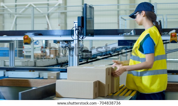 Postal Sorting Office Workers Put Cardboard\
Boxes on Belt Conveyor