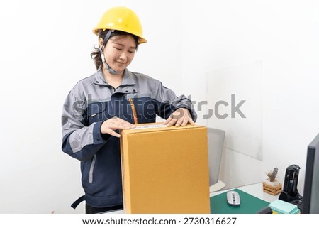 Postal workers handle parcel boxes by attaching barcode stickers.