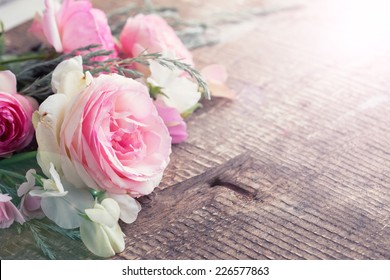 Postcard with fresh roses on  wooden background. Selective focus