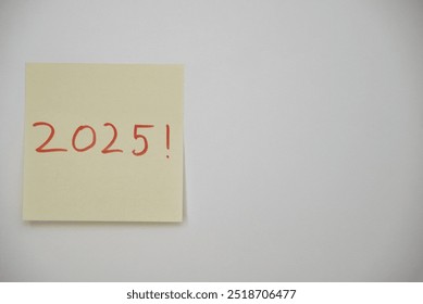 Poste-it note with the year 2025 written in red ink on a white background