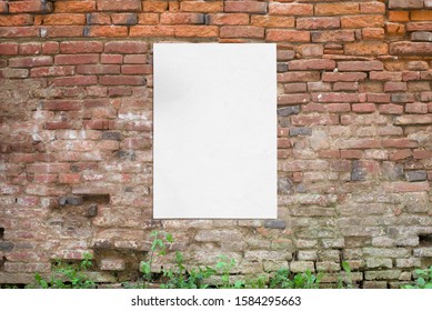 Poster glued to old brick wall. Blank, clean white paper for mockup, design presentation
