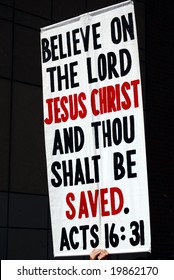 Poster urging people to believe in Jesus, held up during a demonstration