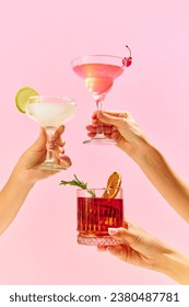 Poster. Variations of alcohol drinks. Capturing hands with funky cocktail glasses, each hosting a uniquely colorful drink, set against colorful studio background. Concept of party, mix. Copy space
