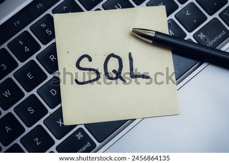 Post-it note with SQL command on laptop keyboard