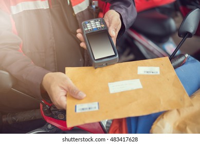 Postman using tablet scanning on the package on delivery.