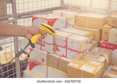 Postman worker scanning package with barcode scanner in warehouse for delivery. - Shutterstock ID 656703736