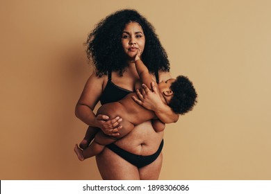 Postpartum Mother Breastfeeding Her Baby. African Woman Nursing Her Baby.