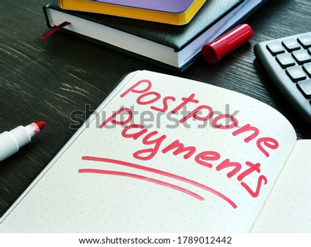 Postpone payments red memo on the page and calculator. Deferment or Forbearance concept.