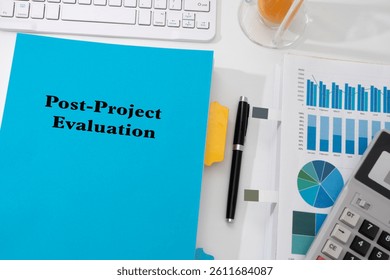 A 'Post-Project Evaluation' document rests on a desk, accompanied by  performance graph, keyboard, and office stationery - symbolizing reflection, analysis, and continuous improvement