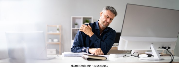 Posture Fatigue Shoulder Pain. Mature Man At Computer Workstation