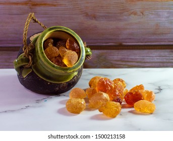 Pot of Arabic gum natural manna resin crystal, mana, senegal acacia on white marble table. Nutritional edible aromatic health food from middle east. 