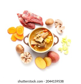 Pot Of Beef Barley Soup And Ingredients On White Background