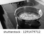 Pot with boiling water on electric stove, space for text