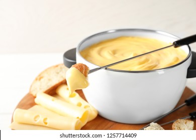 Pot Of Delicious Cheese Fondue And Fork With Bread On Table