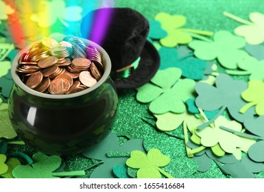 Pot with gold coins, hat and clover leaves on table, space for text. St. Patrick's Day celebration
