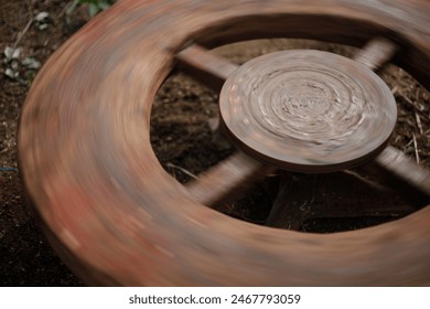 The pot maker uses a running wheel to mold the clay. India, specifically in Telangana and Andra Pradesh.