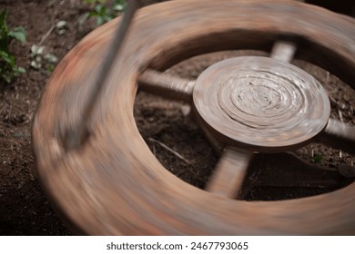 The pot maker uses a running wheel to mold the clay. India, specifically in Telangana and Andra Pradesh.