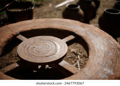 The pot maker uses a running wheel to mold the clay. India, specifically in Telangana and Andra Pradesh.