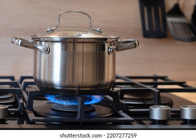 pot on gas stove, stainless pan on the hob, cooking on a gas stove, the cost of gas in Europe - Shutterstock ID 2207277259
