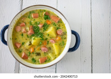 A Pot Of Potato Soup With Vienna Sausage On White Wooden Table