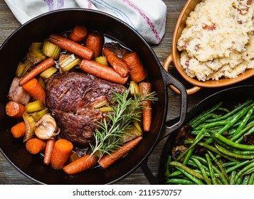 Pot roast in a cast iron dutch oven, green beans and mushed potato. - Shutterstock ID 2119570757